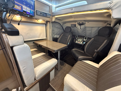 Inside a modern rv rental: dining area, infotainment system, and cockpit. Perfect for road trip adventures, a cozy camper home.