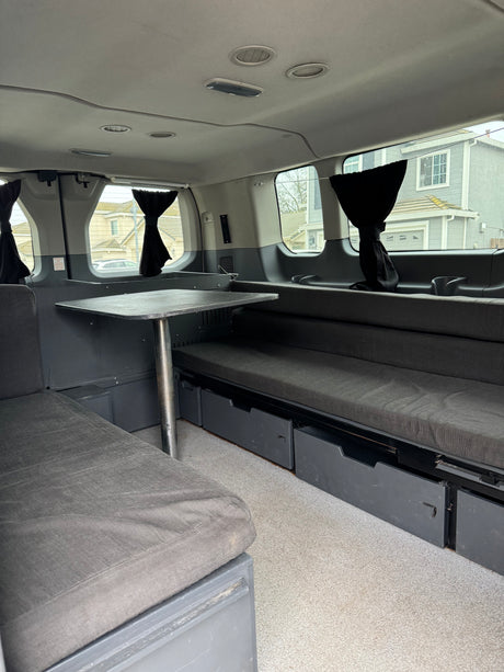 Experience comfort in this rv rental camper van: plush seating, adjustable table, and discreet storage solutions for adventure.
