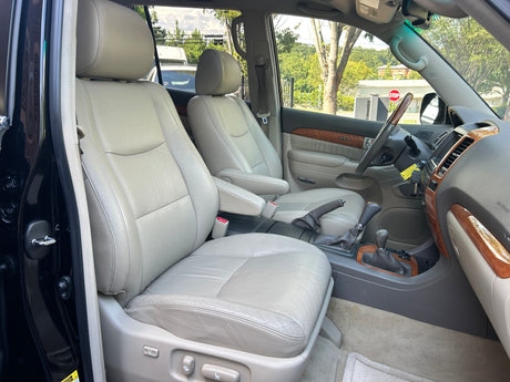 Spacious car interior with light leather seats, wood trim, and dashboard. Ready for an adventure or part of your RV rental fleet.