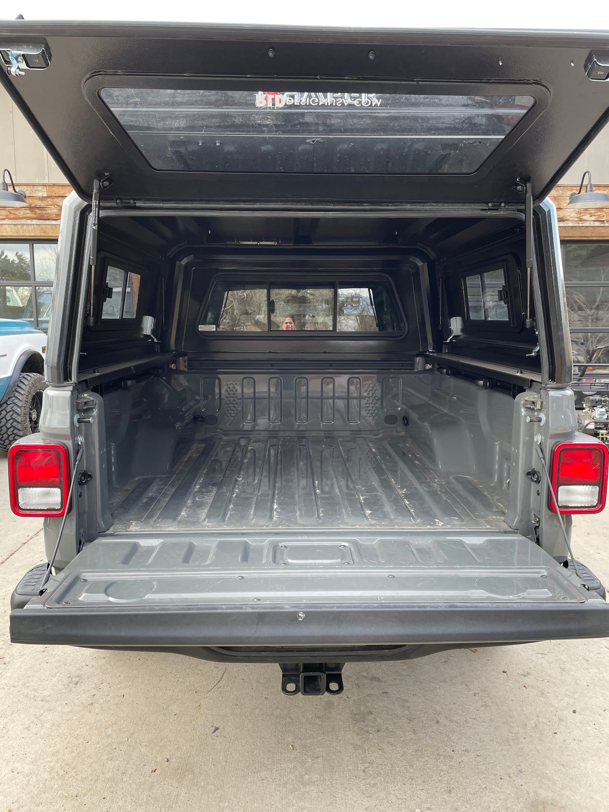  and a dog gaze at mountains. Perfect for an adventurous RV rental trip.|Mobile camping setup: A Jeep with an iKamper rooftop tent and fire pit at sunset — photo 7