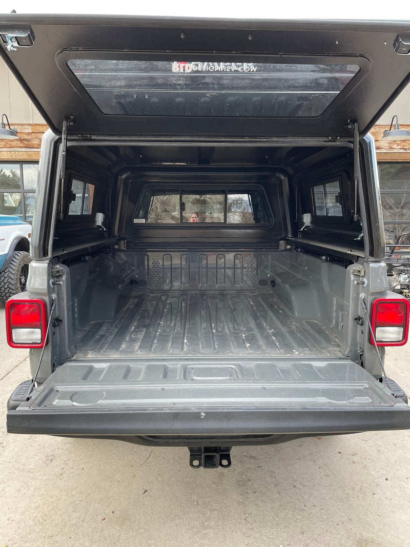  and a dog gaze at mountains. Perfect for an adventurous RV rental trip.|Mobile camping setup: A Jeep with an iKamper rooftop tent and fire pit at sunset — photo 7