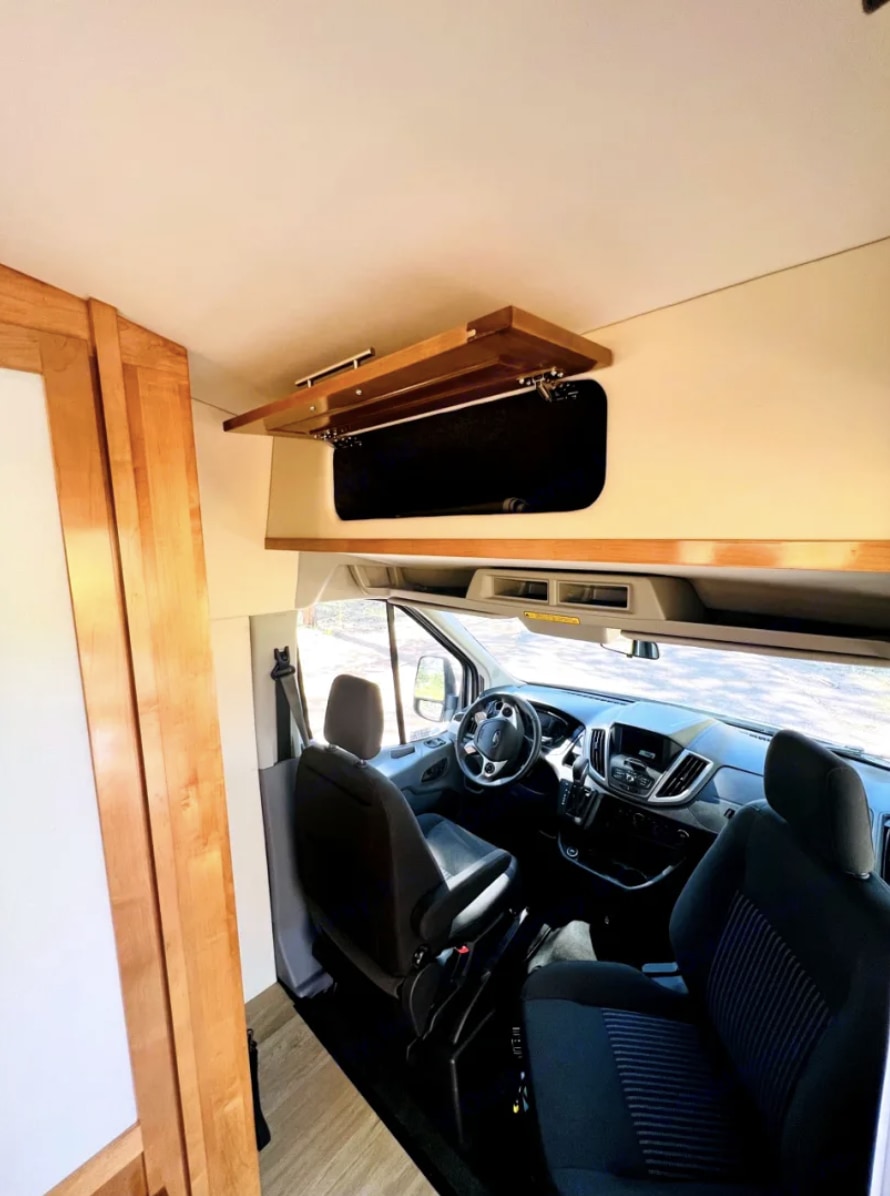  and shower area with curtain.|RV rental interior features comfortable seating — photo 12