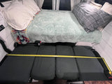 RV rental camper interior: Bed & seating with tape measure across cushions, showing space for travelers.