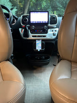 RV rental interior: beige seats frame a modern dashboard with a large infotainment screen and phone mount.