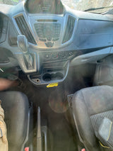 Interior view of an **rv rental** dashboard: gear shifter, radio, climate controls, and cupholders. Driver's leg and passenger seat visible.