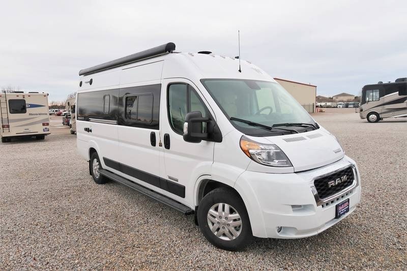 White Ram ProMaster Class B RV for rv rental, parked on a gravel lot.
