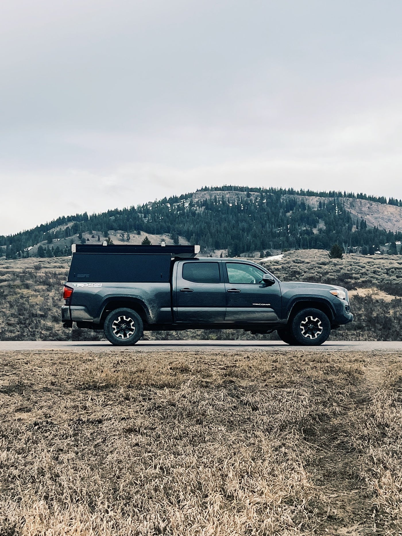  perfect for adventures.|RV rental: A TRD 4x4 truck with a bed camper on a forest road lined by giant trees — photo 5