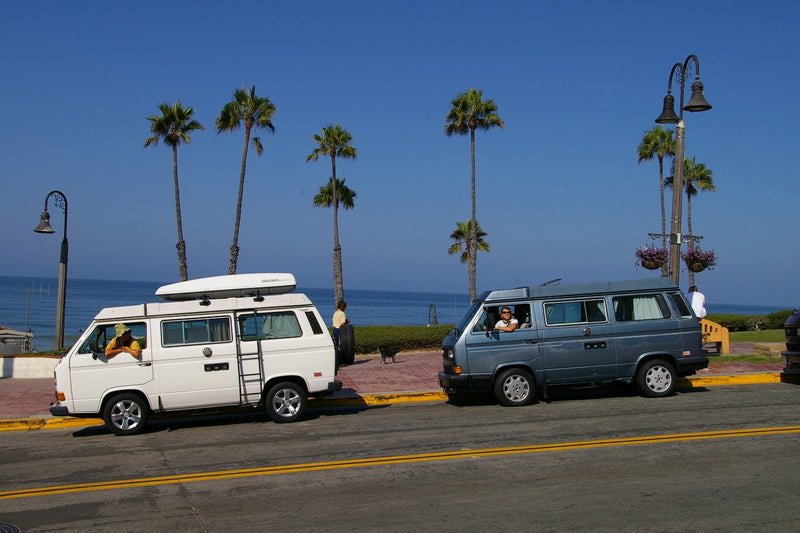 Coastal RV rental trip: Two vintage VW camper vans by the sunny ocean with palm trees. — photo 9