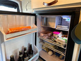 Inside an RV rental, this well-stocked refrigerator with drinks, eggs, and food is ready for your road trip.