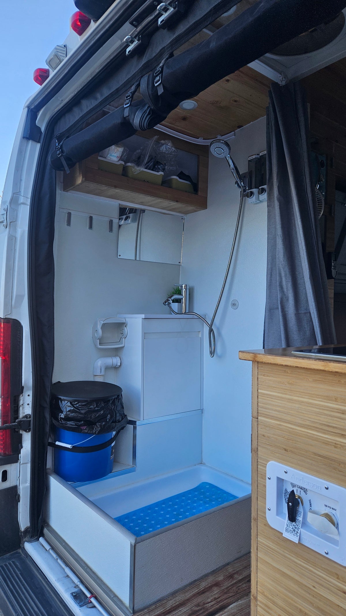 RV rental's compact wet bath showing a shower, sink, and portable toilet, designed for travel convenience. — photo 5