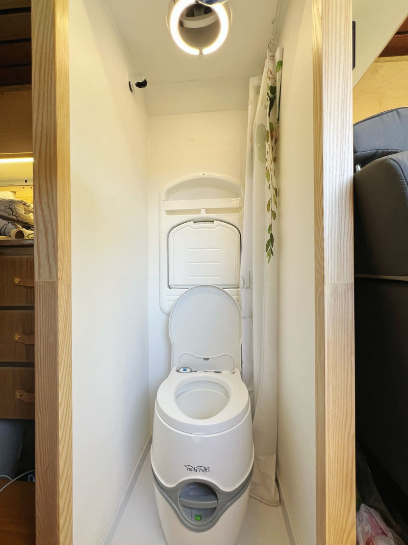  sits on a driveway revealing a custom wood interior.|This RV rental showcases a compact — photo 13
