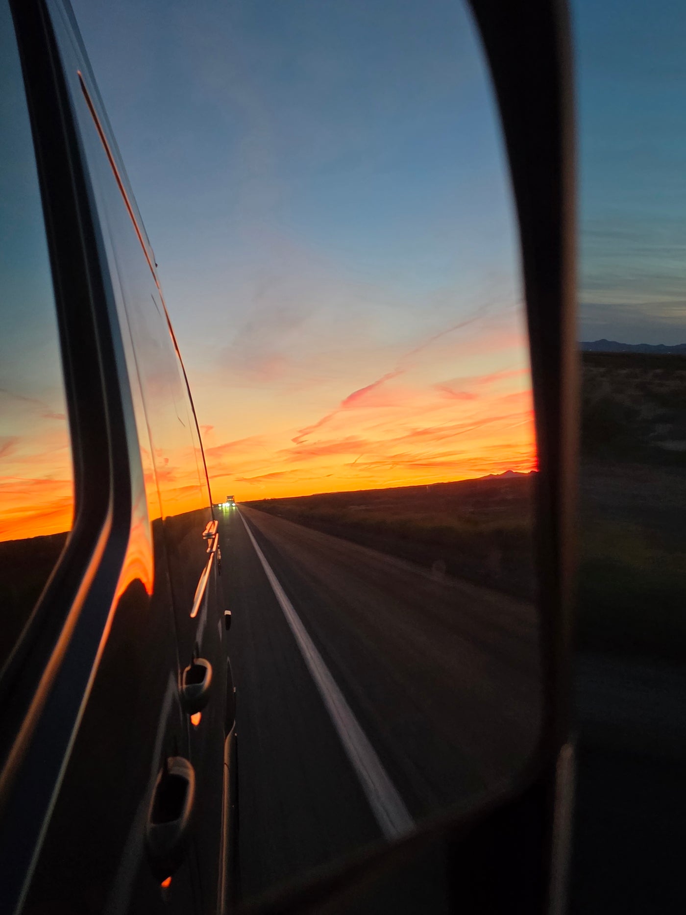 Scenic RV rental road trip at sunset. Vibrant sky reflects on the vehicle, headlights visible on the highway ahead. — photo 20