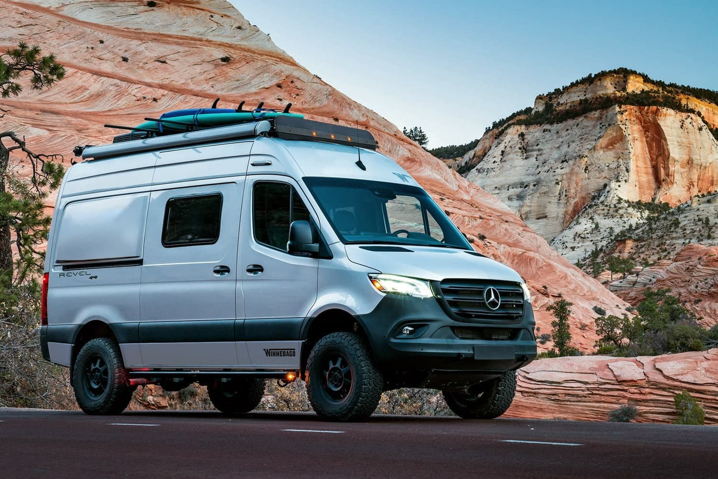 Rugged Winnebago Revel 4x4 camper van, ideal for your next RV rental adventure against a backdrop of red rock mountains. — photo 2