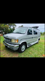 Silver Ford conversion van for RV rental, ideal for travel and camping adventures.