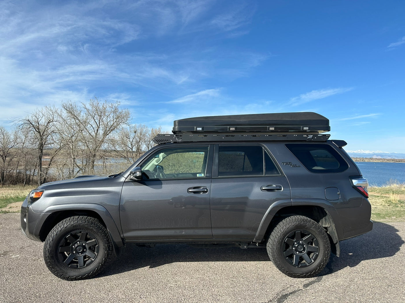  a unique RV rental alternative.|This dark gray Toyota 4Runner SUV with a rooftop tent is perfect for your next RV rental road trip by the lake.|Luxury black leather vehicle interior with TRD headrests & sunroof. A comfortable ride for your next RV rental.|Modern SUV interior: dashboard with infotainment screen — photo 7