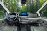Spacious Ford RV rental interior with modern dashboard, large touchscreen display, and a forest view.