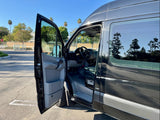 Dark gray Sprinter van, ideal for RV rental, with driver's door open revealing interior. Ready for your next travel adventure.