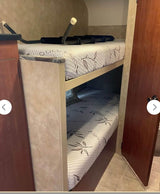 Comfortable bunk beds for your RV rental adventure! Two mattresses with a leaf pattern provide cozy sleeping in this RV interior.