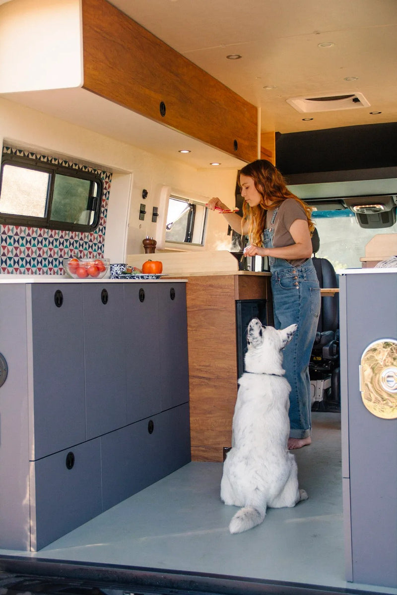 A woman cooks in a stylish rv rental van kitchen — photo 1