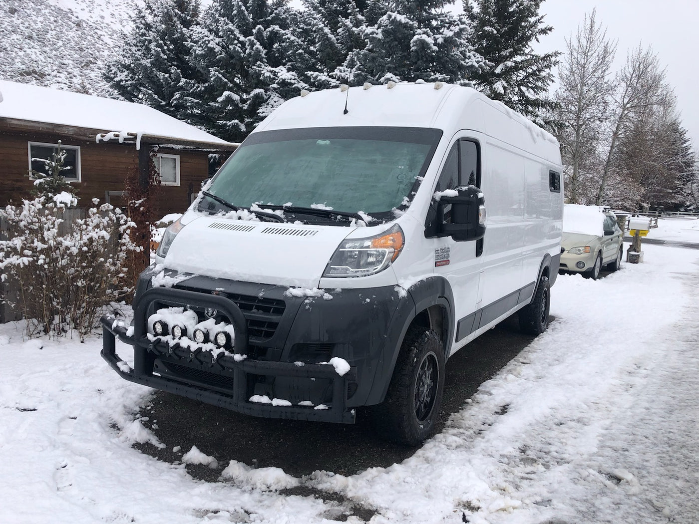 White Ram ProMaster van, equipped for RV rental, covered in fresh snow and parked in a scenic winter landscape. — photo 10