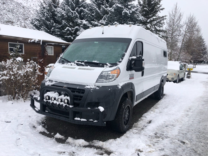 White Ram ProMaster van, equipped for RV rental, covered in fresh snow and parked in a scenic winter landscape. — photo 10