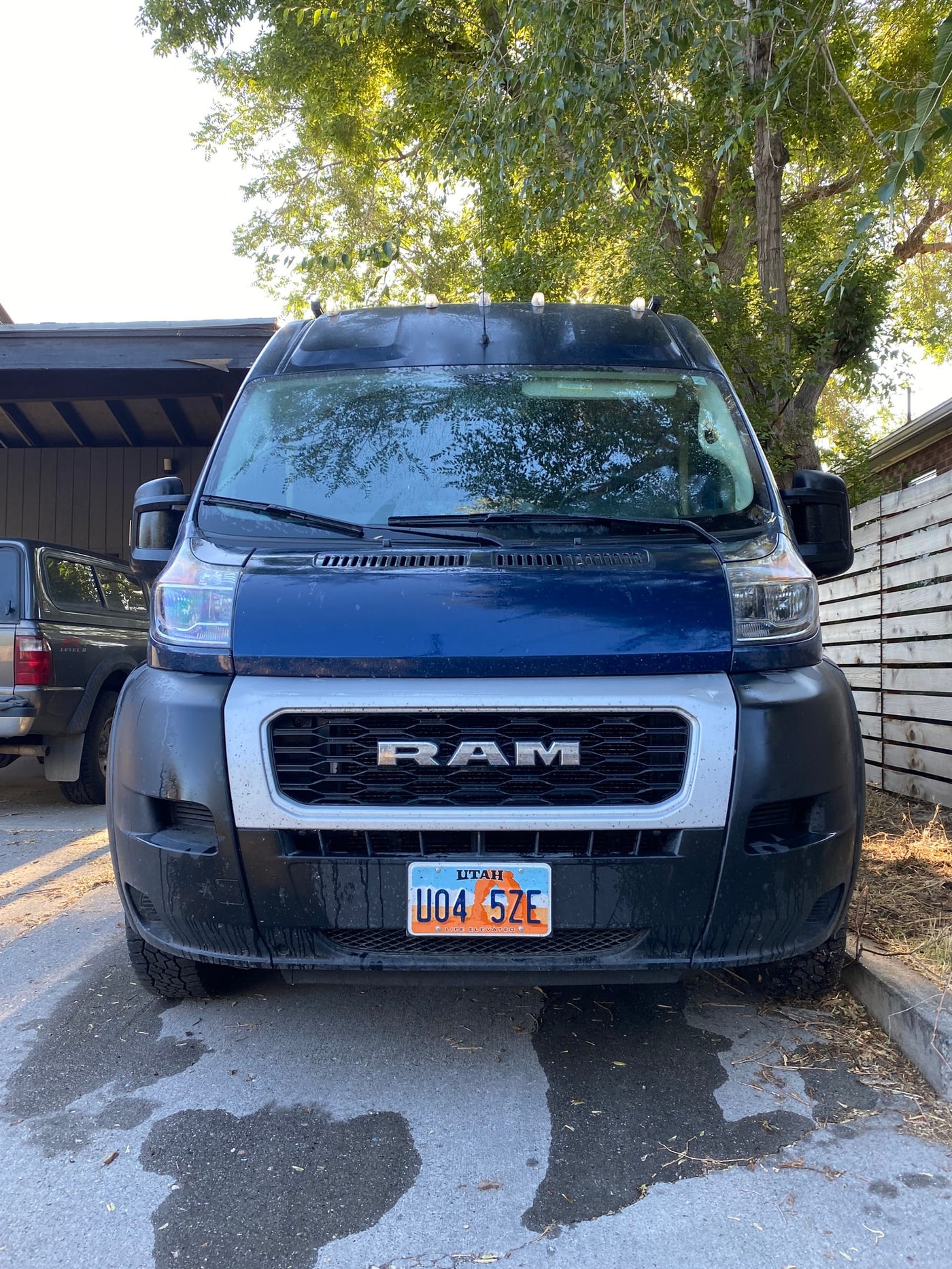 Front view of a blue Ram ProMaster van, a popular RV rental model, with Utah plate U04 5ZE, parked outside. — photo 12