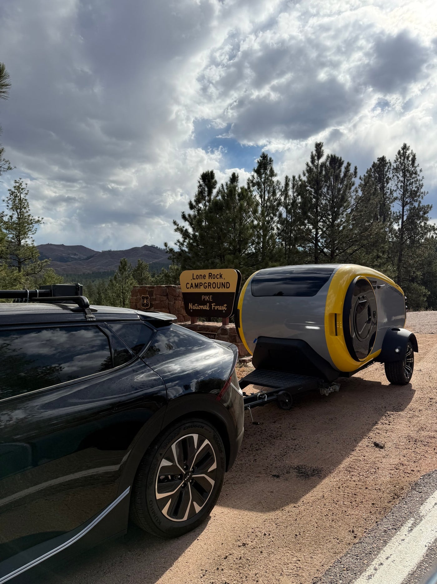 Modern Cortes RV rental for adventure at Lone Rock Campground, Pike National Forest, towed by a black car. — photo 14