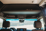 RV rental interior: view of front cabin, overhead storage with gear, and a control panel for lights. Prepared for travel.