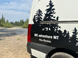 White RV rental van with black tree graphics, parked by a river. WE adventure MT Van Rentals.