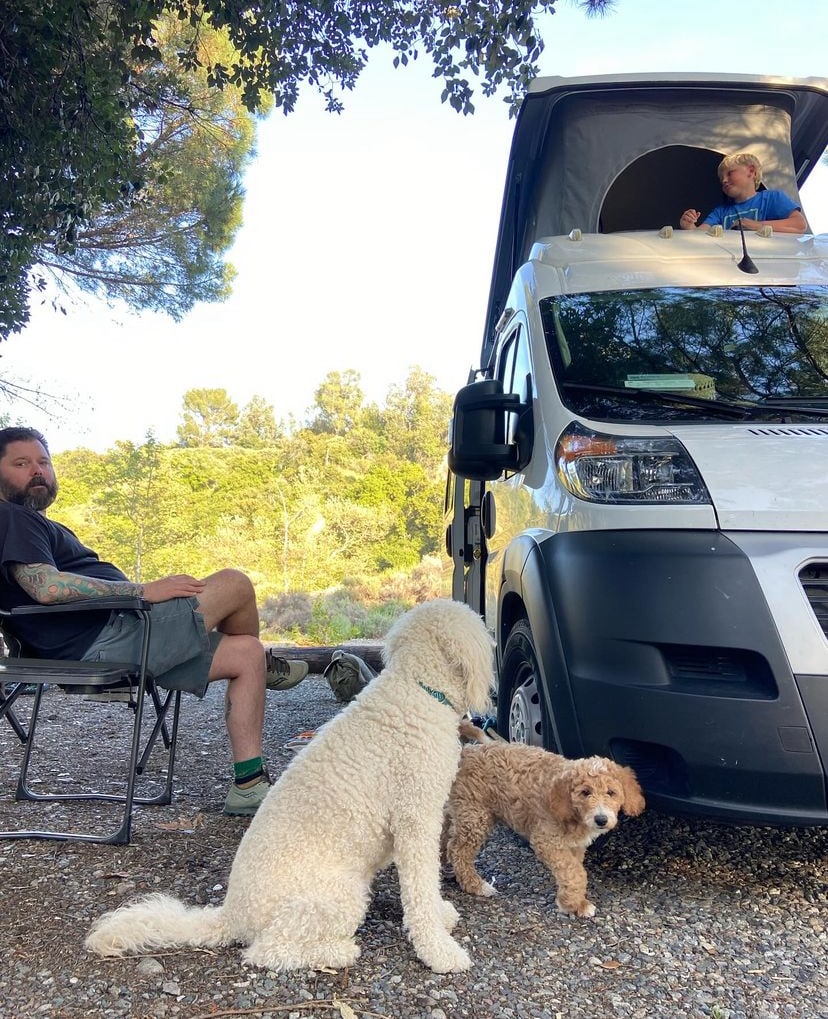  overlooking a snowy landscape.|Smiling boy in waders inside a spacious RV rental. Perfect for family travel & camping adventures.|Family fun & furry friends on an RV rental adventure! A man sits — photo 6