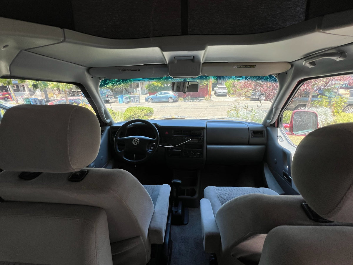  showing a cozy bed setup inside. Perfect for an RV rental road trip adventure!|Inside an RV rental van's cockpit — photo 4