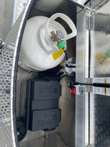 RV rental utility setup: propane tank, battery box, and disconnect switch. Provides power and heating for your trip.