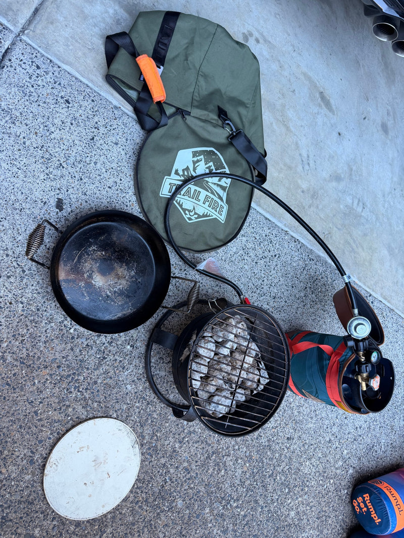 Portable cooking setup for an RV rental: includes a Trail Fire bag, cast iron pan, charcoal grill with briquettes, and a propane tank kit. — photo 10