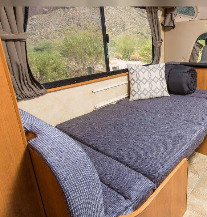  ready for your road trip meals.|RV rental interior: a compact sleeping area with a rolled sleeping bag in the cab-over bunk — photo 3