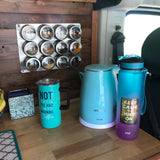 RV rental: a vibrant collection of travel essentials – kettle, water bottle, coffee mug, and magnetic spices on wood.