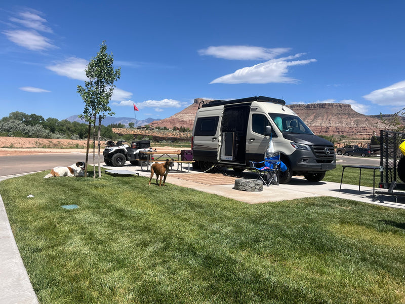 This RV rental is set up for a fun camping trip with dogs and an ATV against scenic red rock mountains. — photo 20