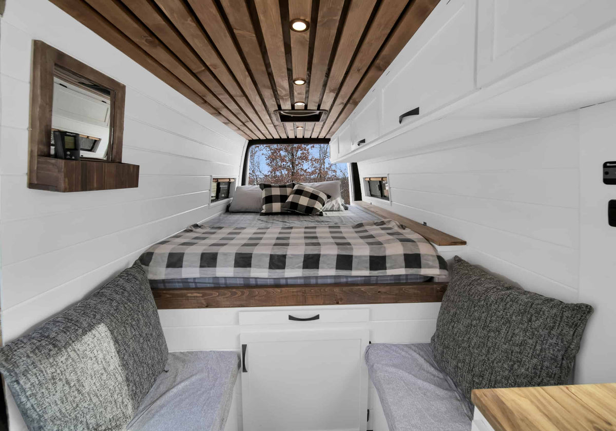 Cozy RV rental bedroom with wooden slat ceiling, white shiplap walls, and a checkered bed. Ideal for van life adventures. — photo 6