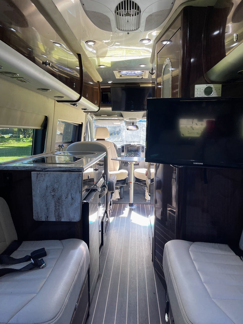 Inside this spacious RV rental, find a modern kitchen, dining area, and dual TVs for comfortable travel. — photo 12