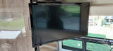 Enjoy entertainment in your RV rental! View of a TV mounted in the living space with outdoor scenery visible through windows.