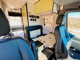 Step inside this cozy RV rental! Features a dinette with portable table, main seating, and control panel. A bed is visible in the rear.
