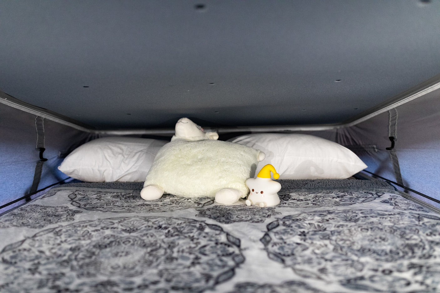 Cozy RV rental sleeping area with soft pillows and cute plushies for a comfortable night's sleep.