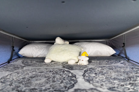 Cozy RV rental sleeping area with soft pillows and cute plushies for a comfortable night's sleep.