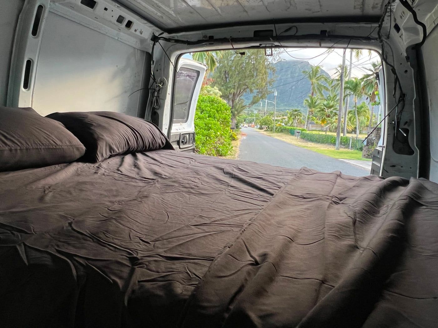  parked on dirt. Reflections visible in windows.|Cozy rv rental bed inside a van — photo 4