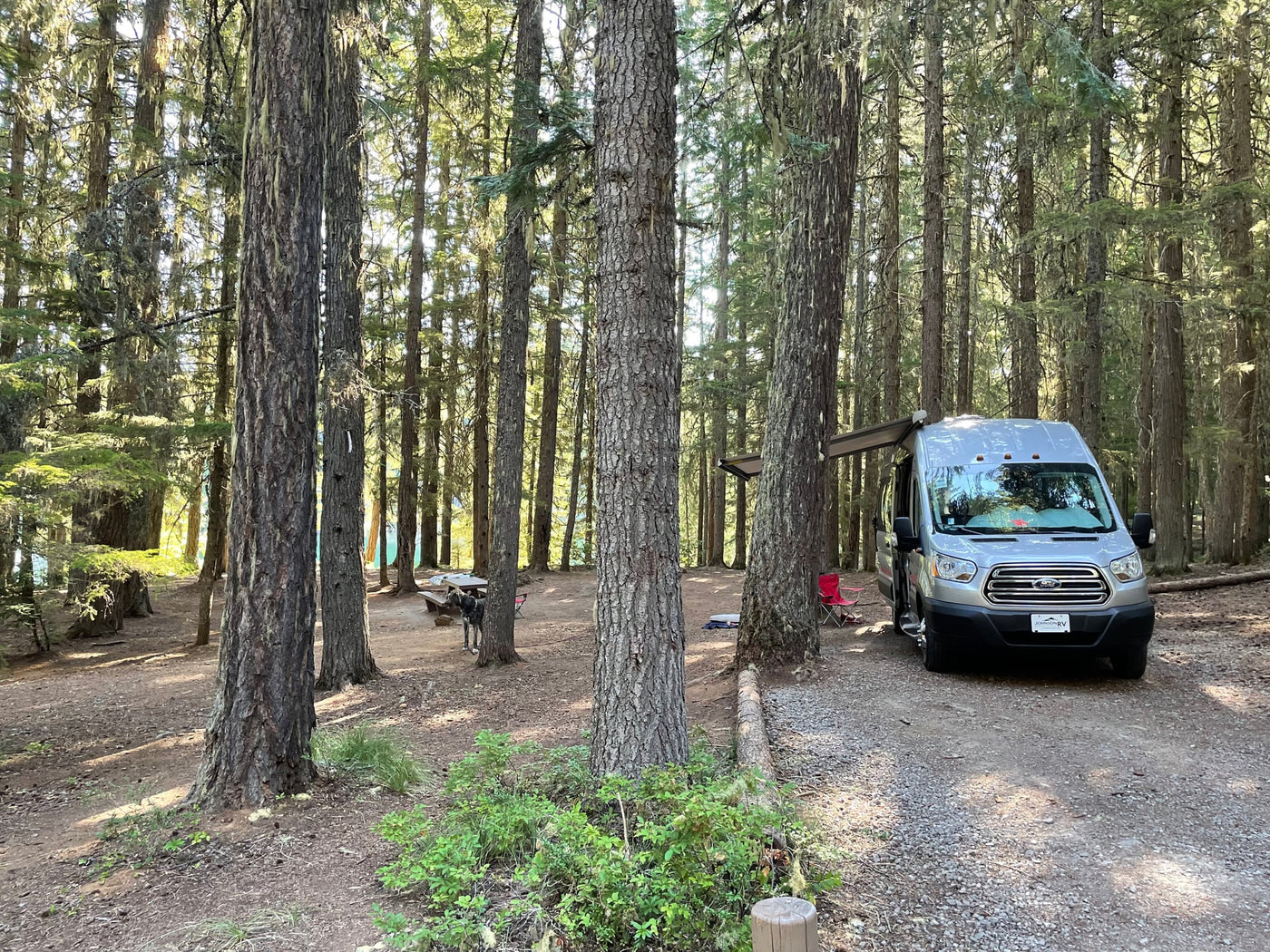  complete with picnic table breakfast setup.|Inside a comfy RV rental: parallel sleeping areas with cushions — photo 19