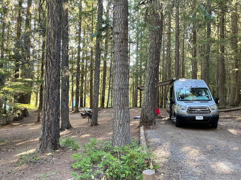  complete with picnic table breakfast setup.|Inside a comfy RV rental: parallel sleeping areas with cushions — photo 19