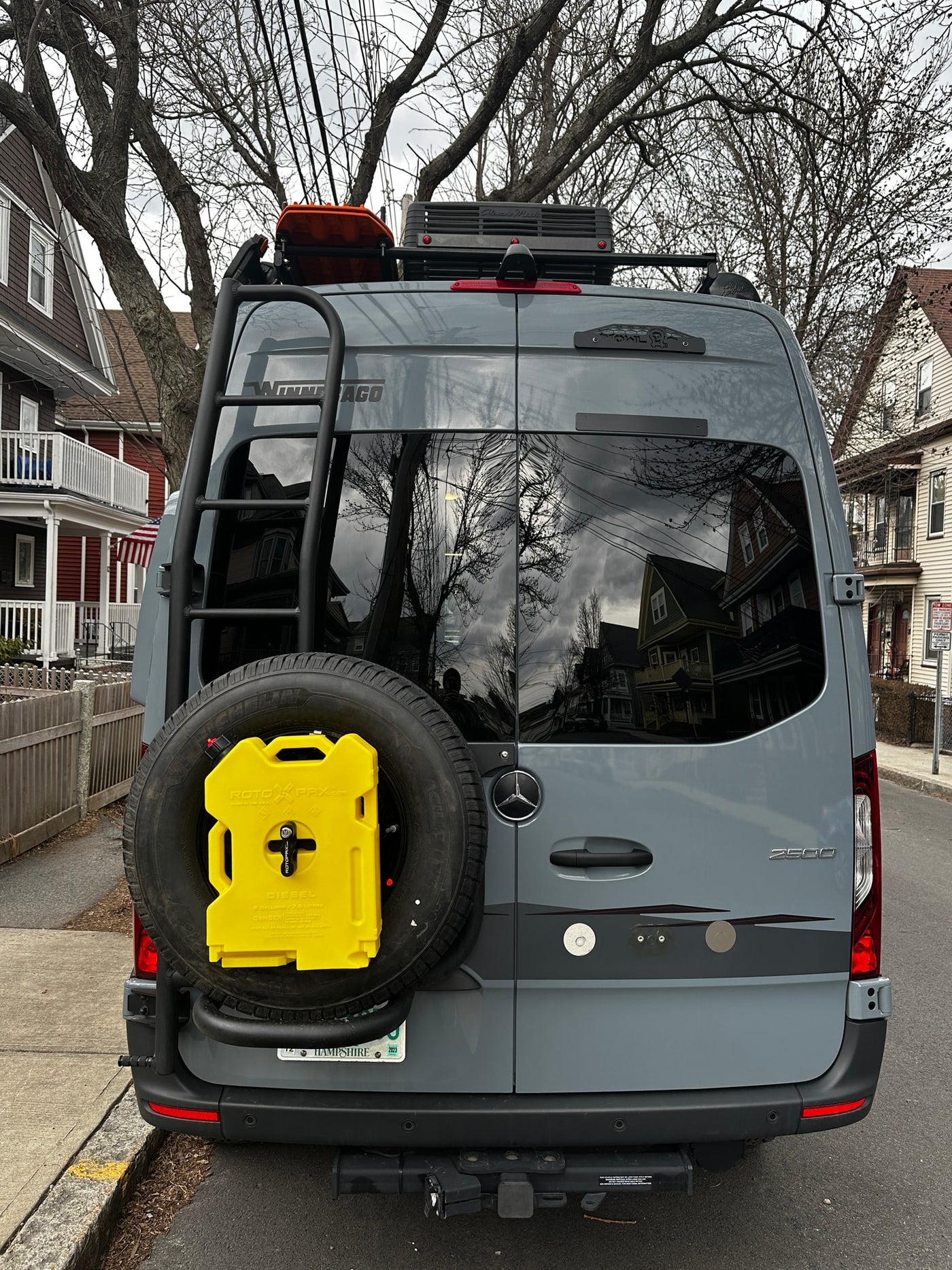 Winnebago RV rental: Grey Sprinter van with rear ladder, spare tire, Rotopax fuel, and roof rack gear. — photo 6