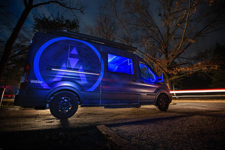 Custom blue-lit camper van with topo map design by Vandoit, ideal for your next RV rental adventure at night.