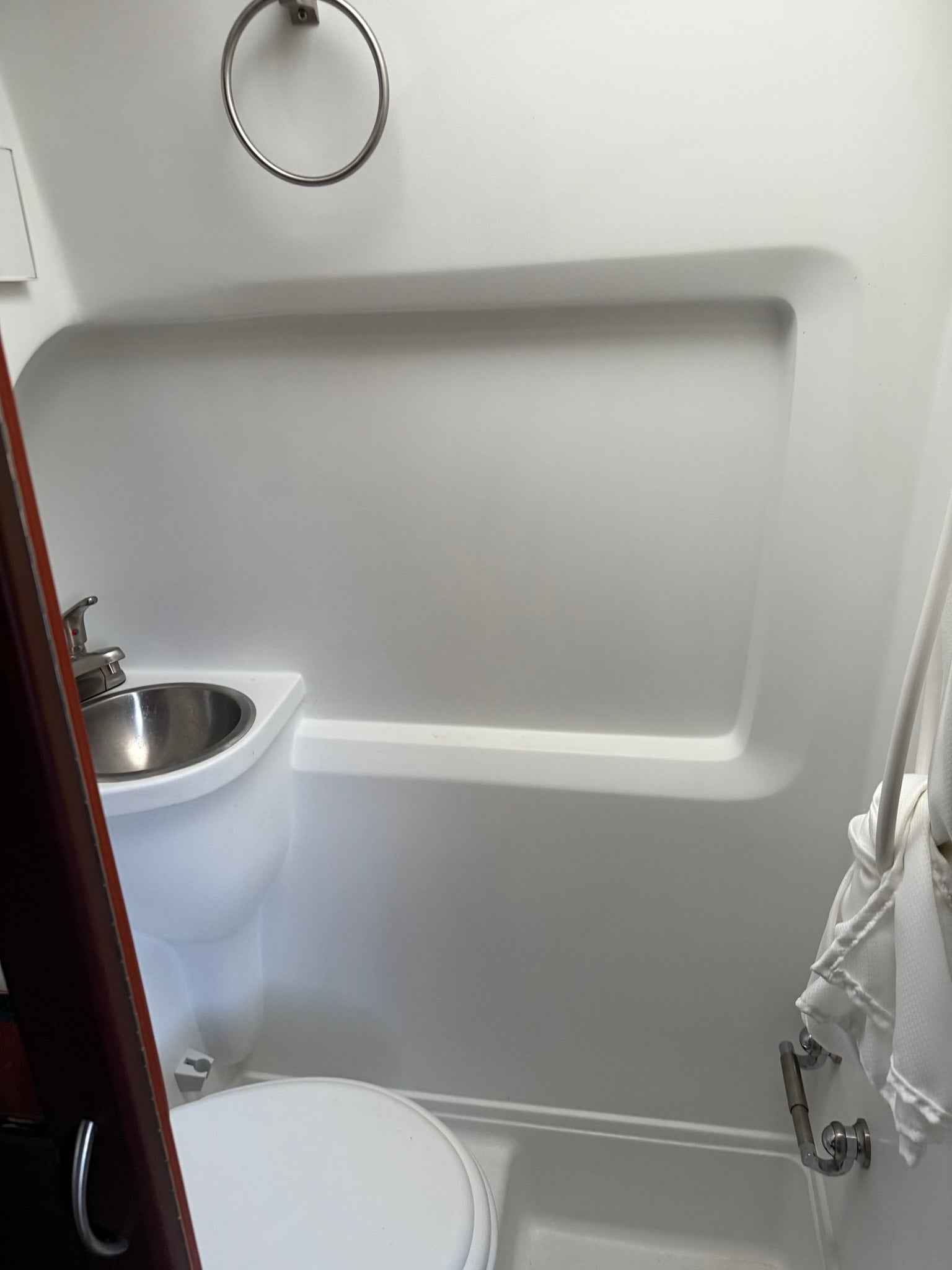RV rental interior: compact bathroom with sink, toilet, and shower curtain.