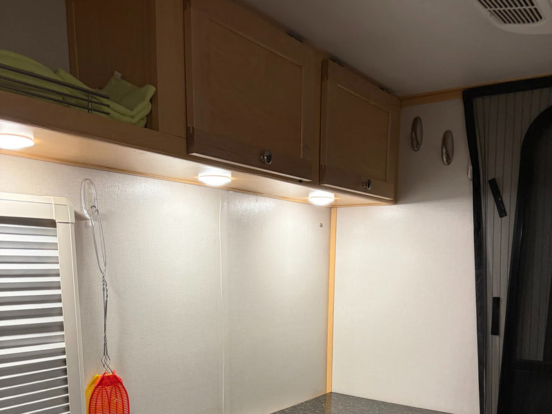  and a comfy dinette.|RV rental interior: A compact kitchen area featuring integrated cooktops — photo 9