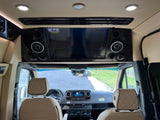 Luxury RV rental interior with TV, speakers, and plush front cabin. Ideal for comfortable road trips.